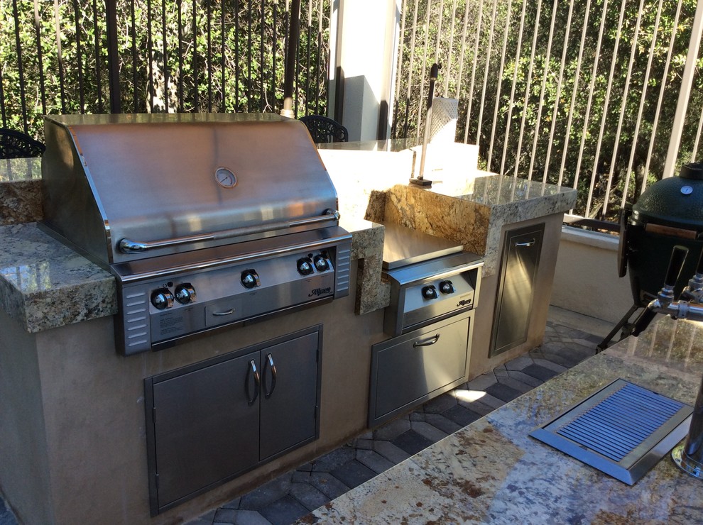 Photo of a large modern back patio in Los Angeles with an outdoor kitchen, stamped concrete and a pergola.