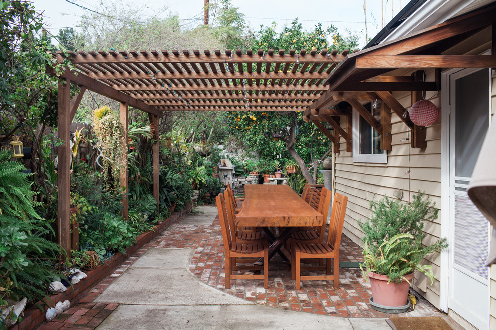 Mittelgroße Urige Pergola hinter dem Haus mit Kübelpflanzen und Pflastersteinen in Orange County