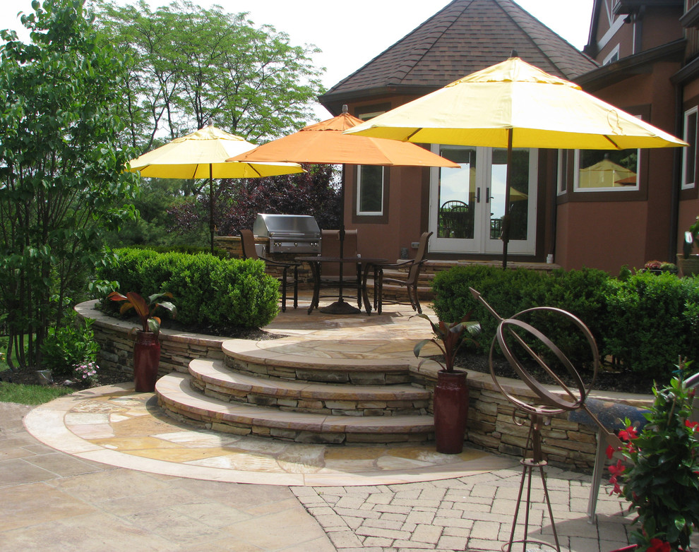 Immagine di un patio o portico stile rurale di medie dimensioni e dietro casa con pavimentazioni in pietra naturale e nessuna copertura
