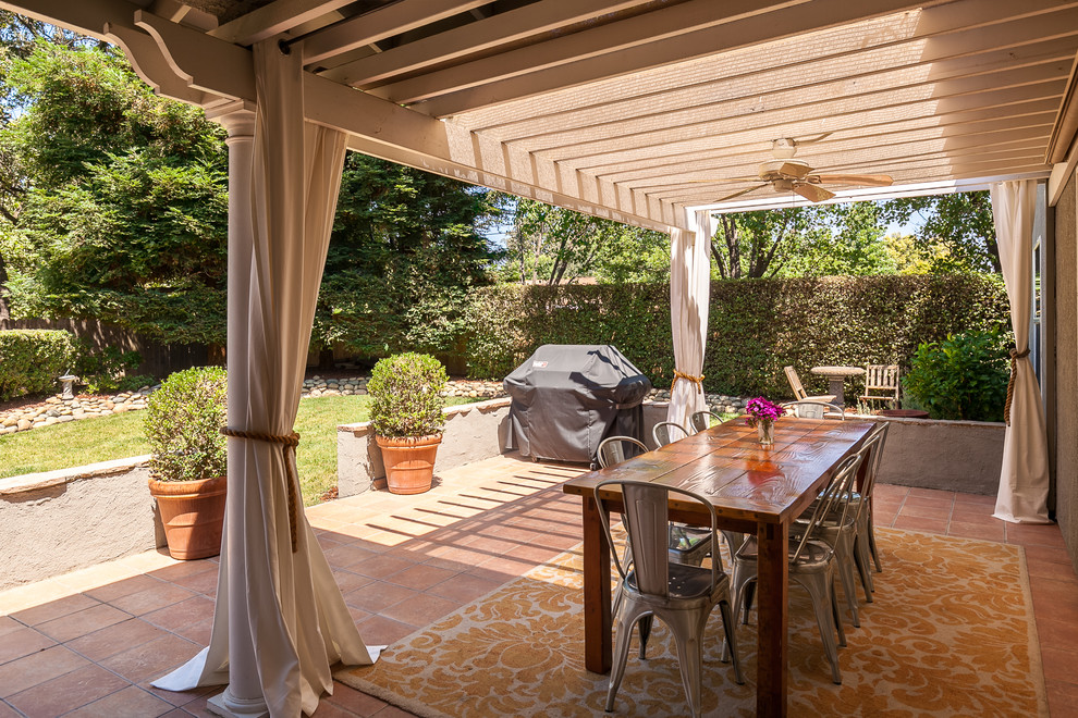 This is an example of a medium sized bohemian back patio in Other with tiled flooring and a pergola.