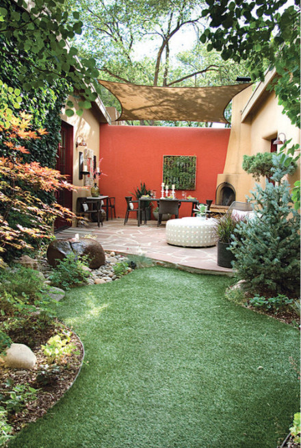 Foto de patio contemporáneo de tamaño medio sin cubierta en patio trasero con brasero y adoquines de piedra natural