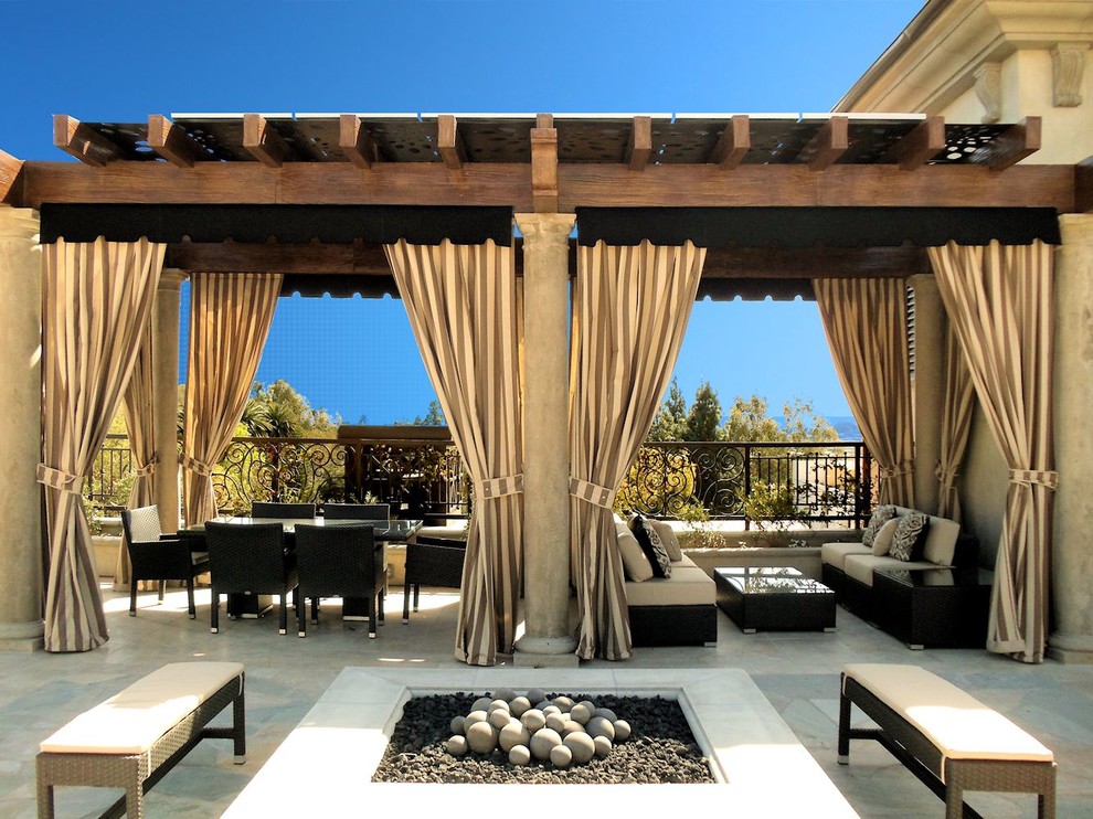 Photo of a mediterranean patio in Los Angeles with a fire feature and a pergola.