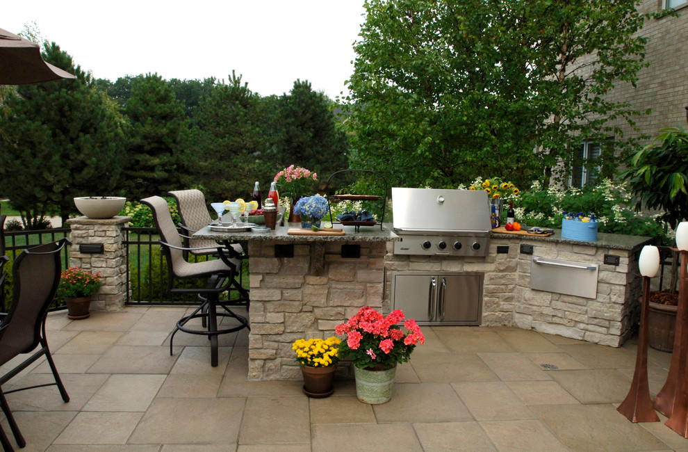 Idée de décoration pour une grande terrasse arrière design avec une cuisine d'été, des pavés en béton et une pergola.