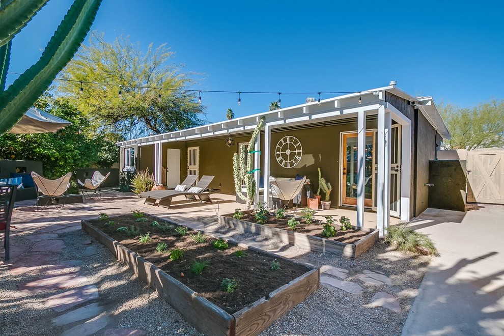 Example of a mid-sized transitional backyard gravel patio vegetable garden design in Phoenix with a roof extension