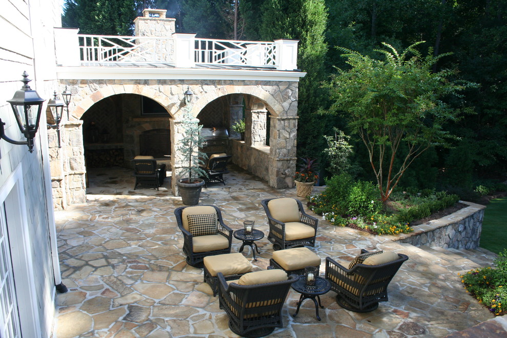 На фото: большой двор на заднем дворе в средиземноморском стиле с летней кухней, покрытием из каменной брусчатки и навесом с