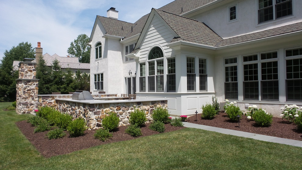Esempio di un grande patio o portico tradizionale dietro casa con pavimentazioni in pietra naturale