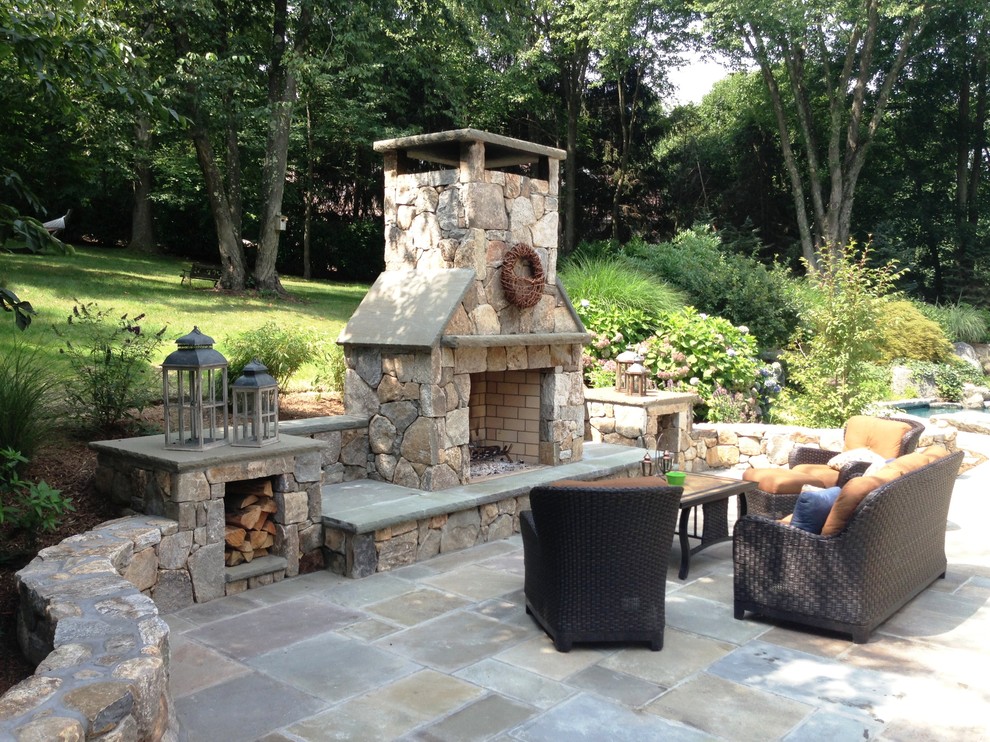 Inspiration for a medium sized classic back patio in New York with a fire feature, natural stone paving and no cover.
