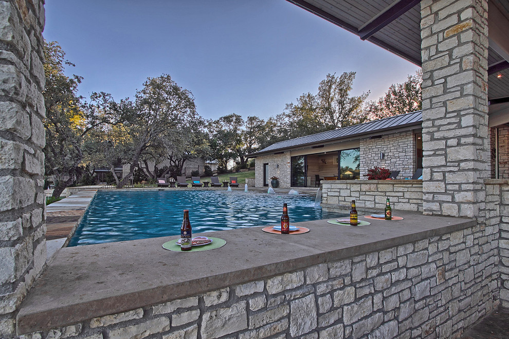 Geräumiger Moderner Patio neben dem Haus mit Outdoor-Küche, Natursteinplatten und Gazebo in Austin