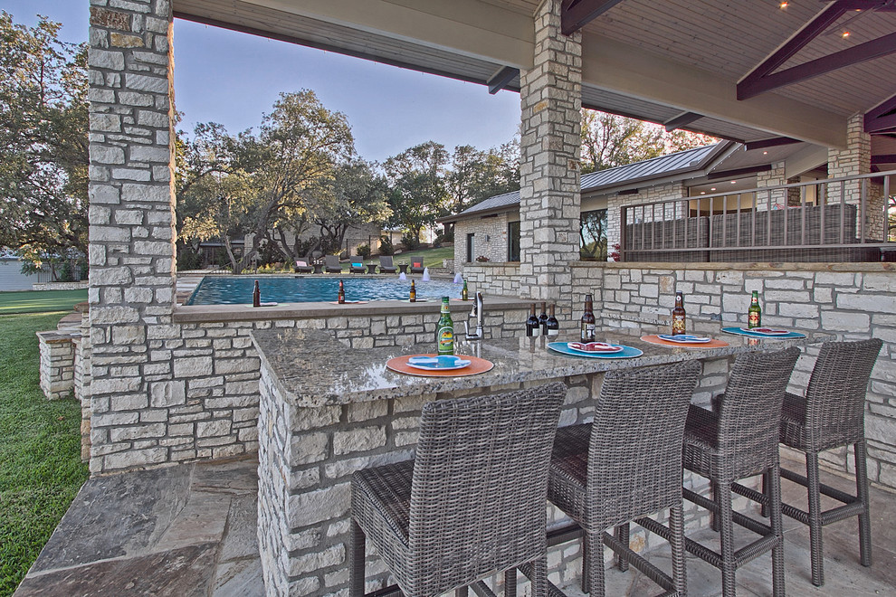 Modelo de patio actual extra grande en patio lateral con cocina exterior, adoquines de piedra natural y cenador