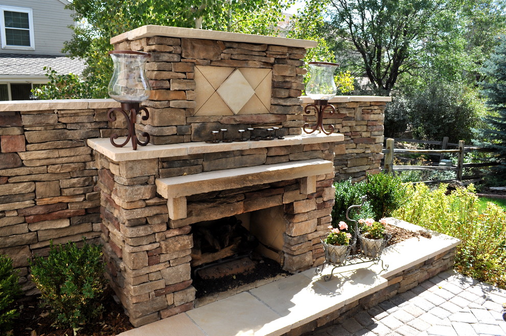 Example of a mid-sized classic backyard stone patio design in Denver with a fire pit and no cover