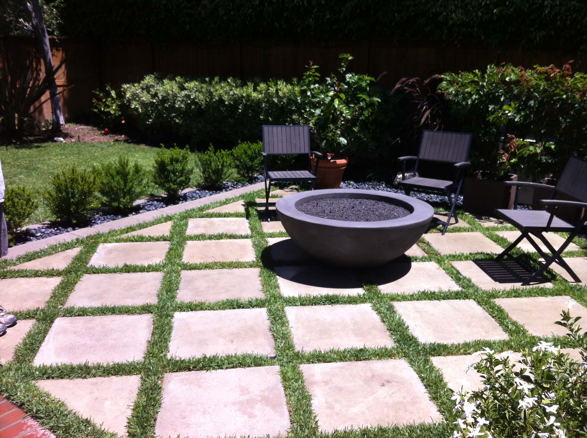 DIY patio with grass between pavers and a fire pit!