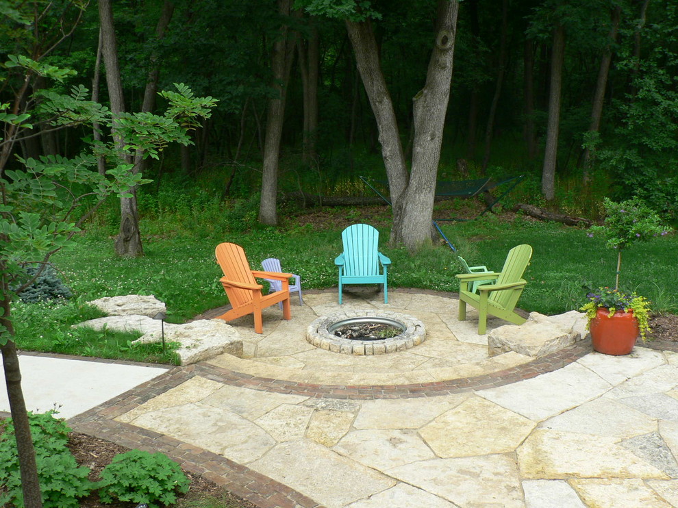 Inspiration for a mid-sized rustic backyard stone patio remodel in Milwaukee with a fire pit and no cover