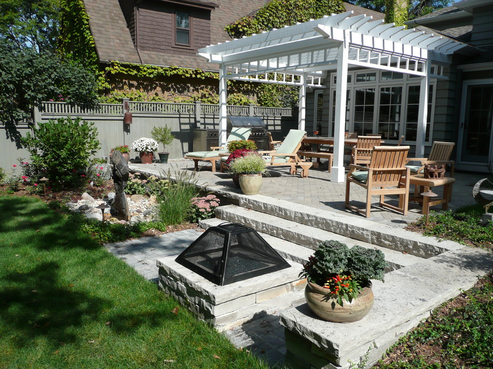 Idee per un piccolo patio o portico minimal dietro casa con un focolare, pavimentazioni in mattoni e una pergola