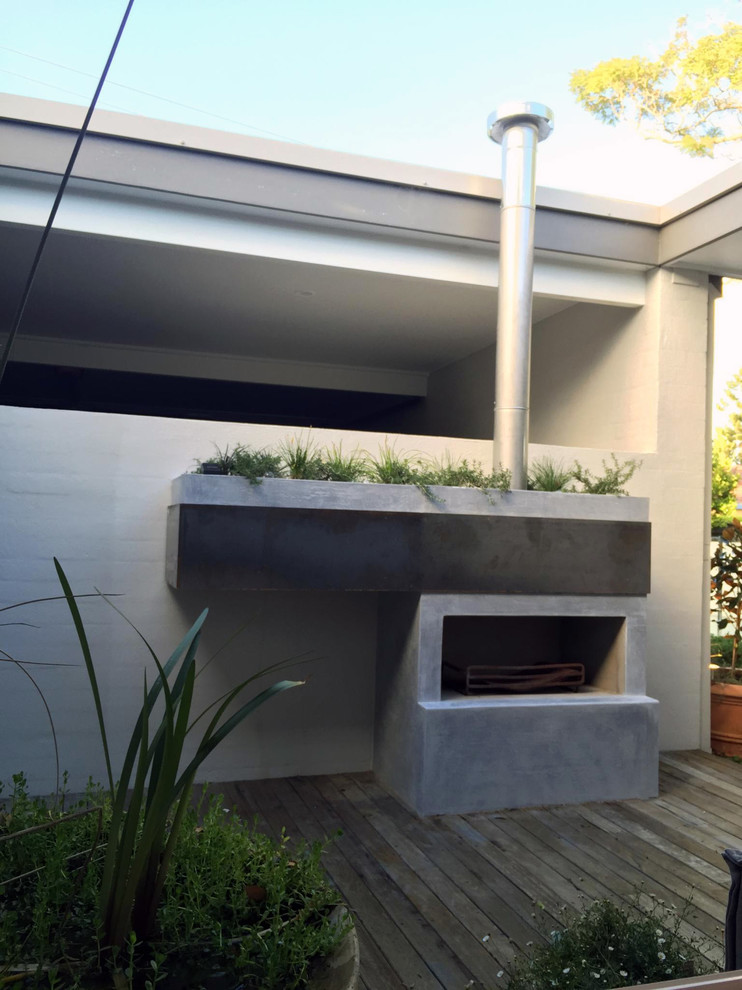 Imagen de patio minimalista pequeño sin cubierta en patio trasero con brasero y entablado