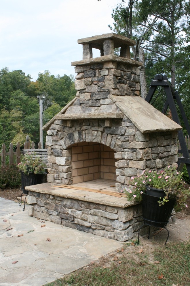 Diseño de patio de estilo americano pequeño sin cubierta en patio trasero con chimenea y adoquines de piedra natural