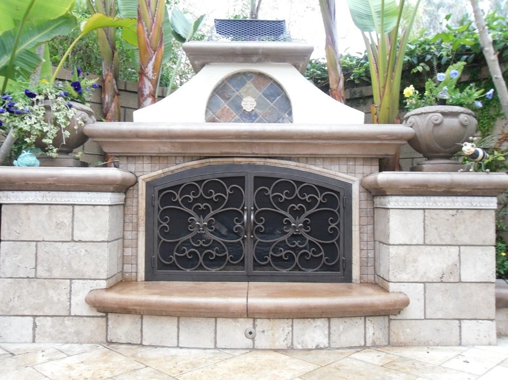 Photo of a medium sized world-inspired back patio in San Diego with a fire feature, stamped concrete and no cover.