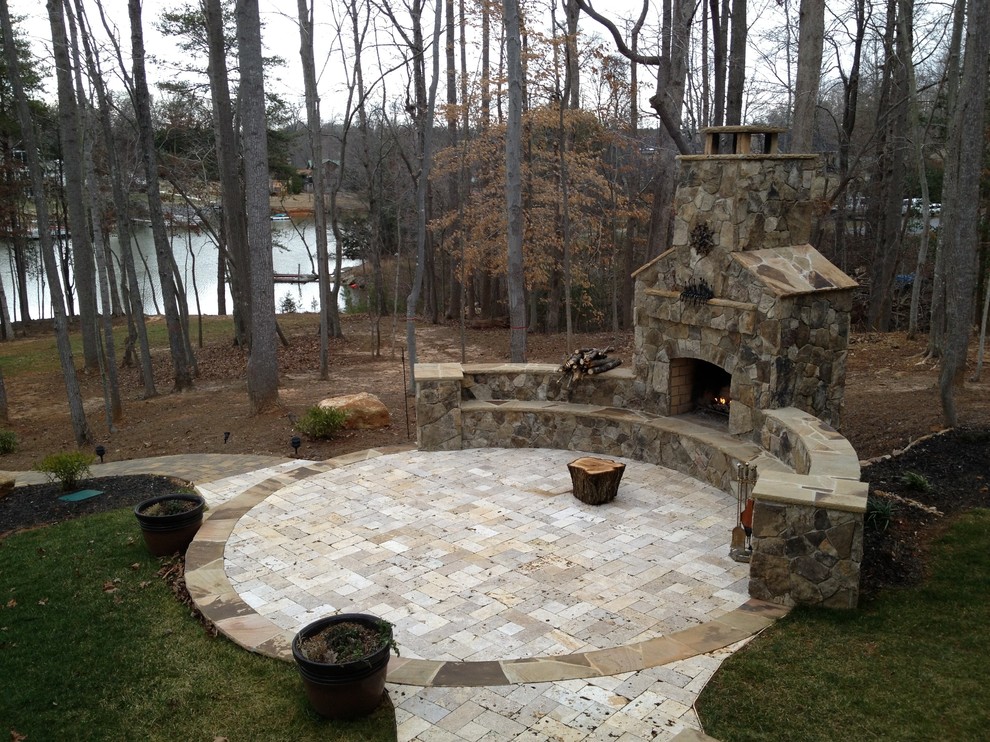 Inspiration for a large craftsman courtyard stone patio remodel in Charlotte with a fire pit and no cover