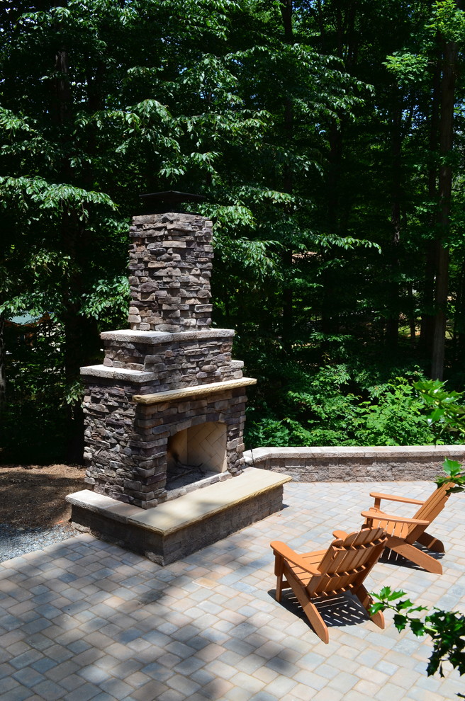 Mid-sized elegant backyard concrete paver patio photo in DC Metro with a fire pit