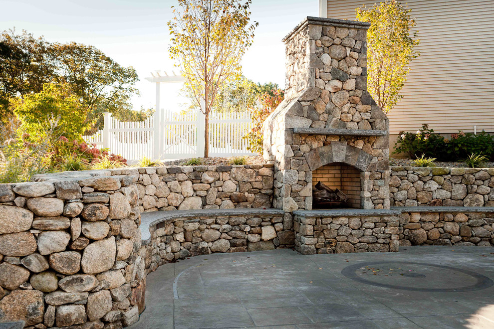 Inspiration for a mid-sized rustic backyard stone patio remodel in Boston with a fire pit and no cover