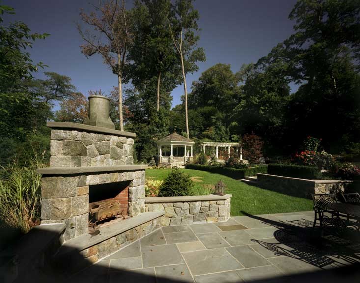 Esempio di un grande patio o portico classico dietro casa con un focolare, pavimentazioni in pietra naturale e nessuna copertura