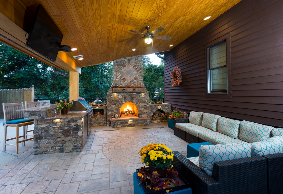 Example of a mid-sized mountain style backyard concrete paver patio kitchen design in Raleigh with a roof extension