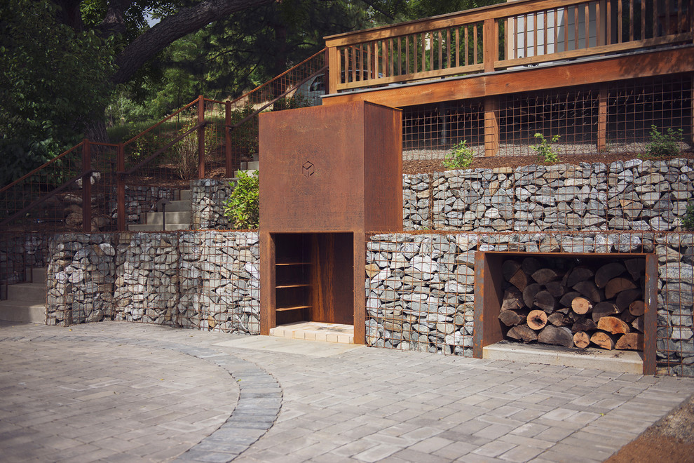 Idee per un grande patio o portico moderno dietro casa con un focolare, pavimentazioni in cemento e nessuna copertura