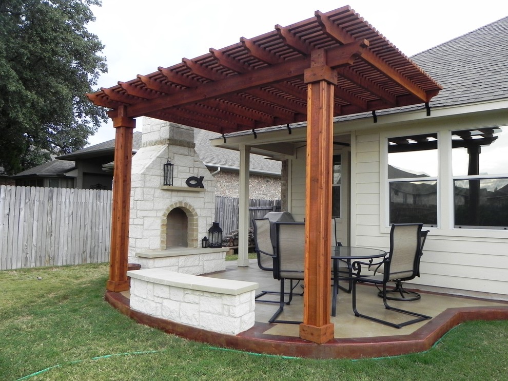 Small classic back patio in Austin with a fire feature, concrete slabs and a pergola.