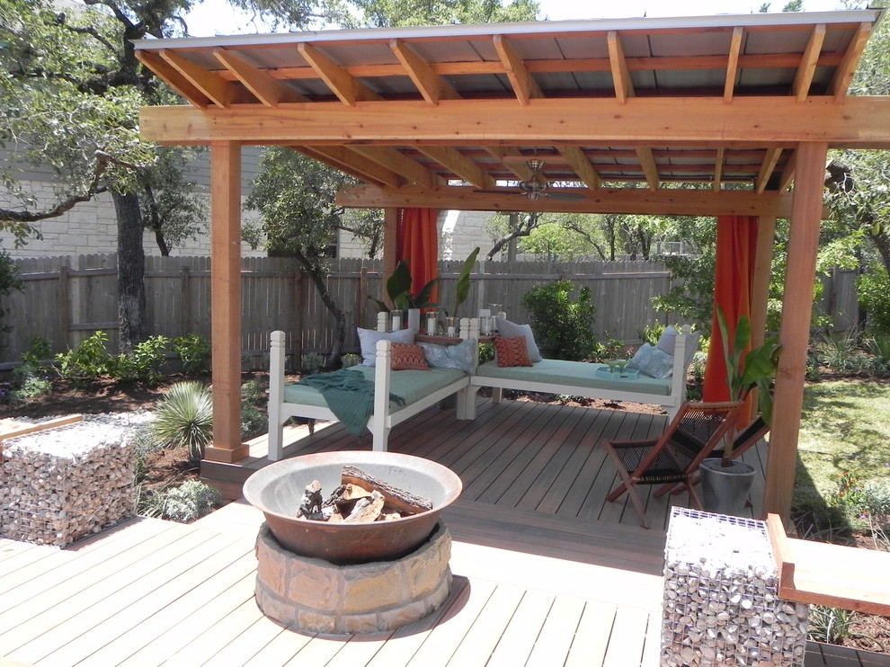 Inspiration for a small contemporary backyard patio remodel in Austin with a fire pit, decking and a pergola