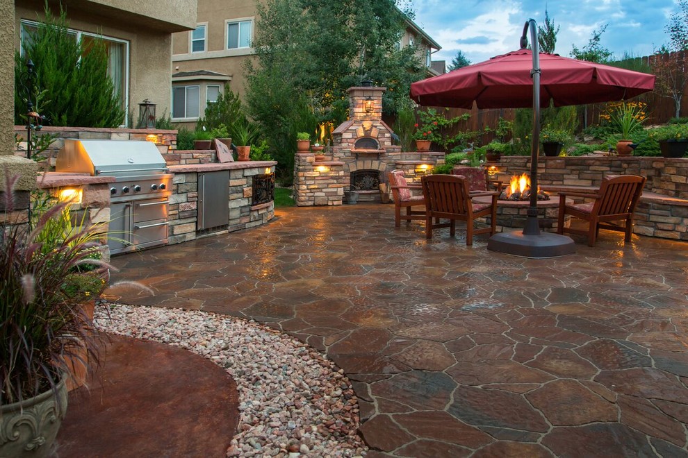Inspiration for a large traditional back patio in Charlotte with stamped concrete.