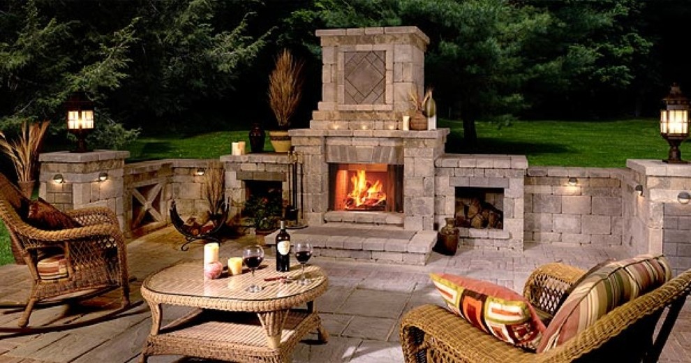 This is an example of a traditional back patio in New York with a fire feature and natural stone paving.