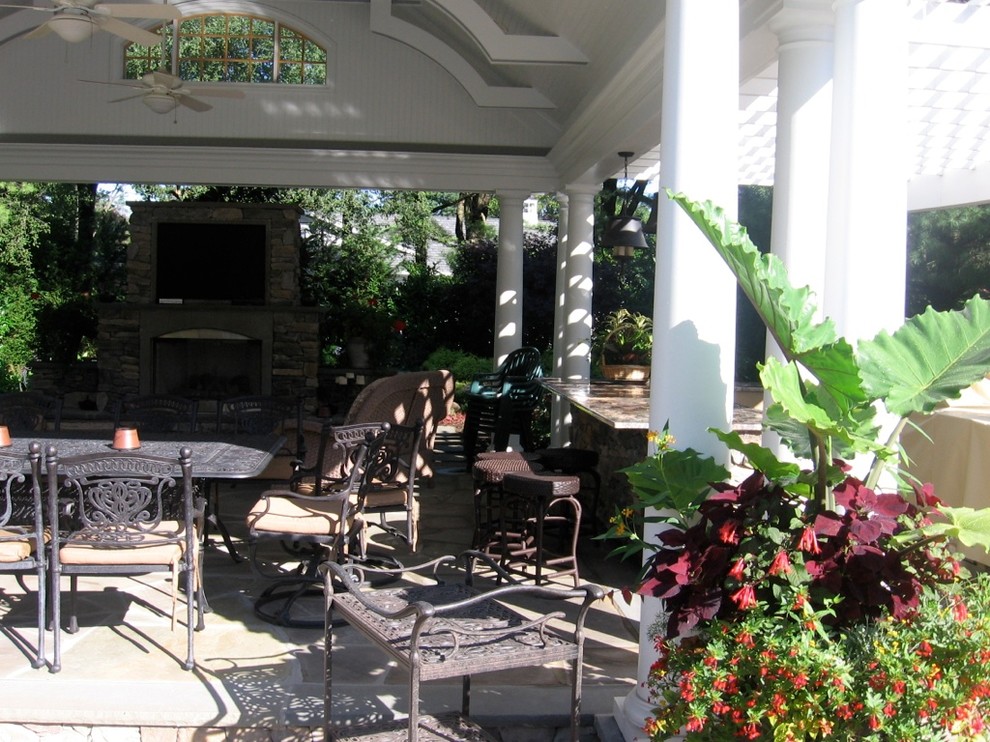 Esempio di un patio o portico classico dietro casa con un focolare e pavimentazioni in pietra naturale