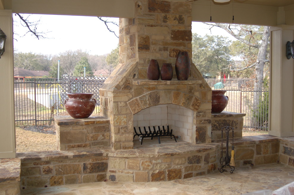 Überdachter, Großer Uriger Patio hinter dem Haus mit Feuerstelle und Natursteinplatten in Austin