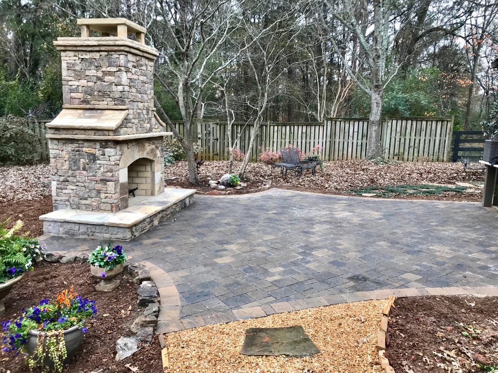 Large contemporary back patio in Atlanta with a fire feature, natural stone paving and no cover.