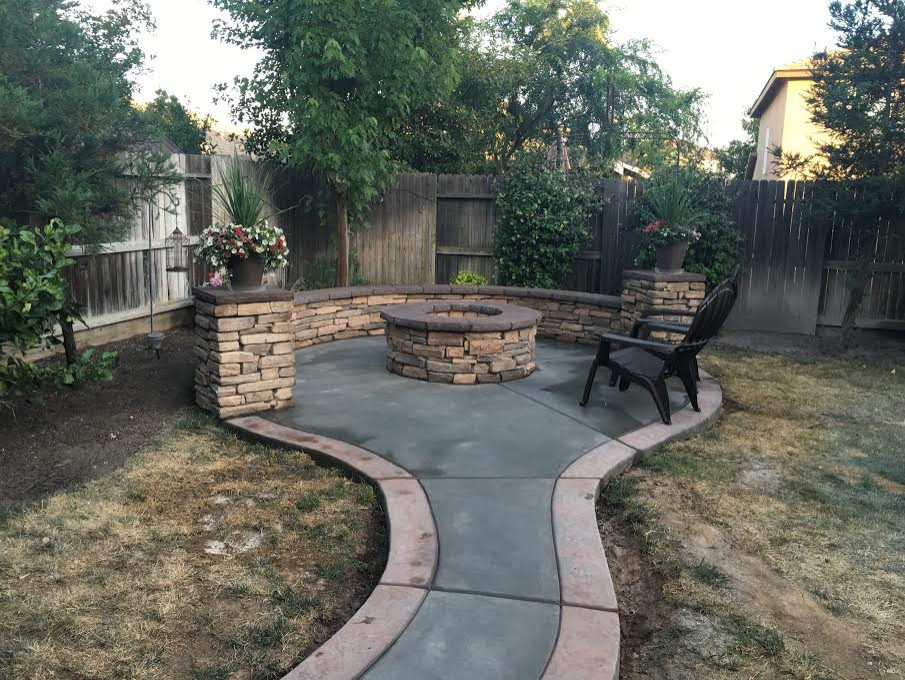Photo of a medium sized classic back patio in Other with a fireplace, stamped concrete and a gazebo.