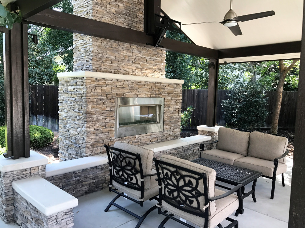 Foto di un patio o portico american style di medie dimensioni e dietro casa con un caminetto, lastre di cemento e una pergola