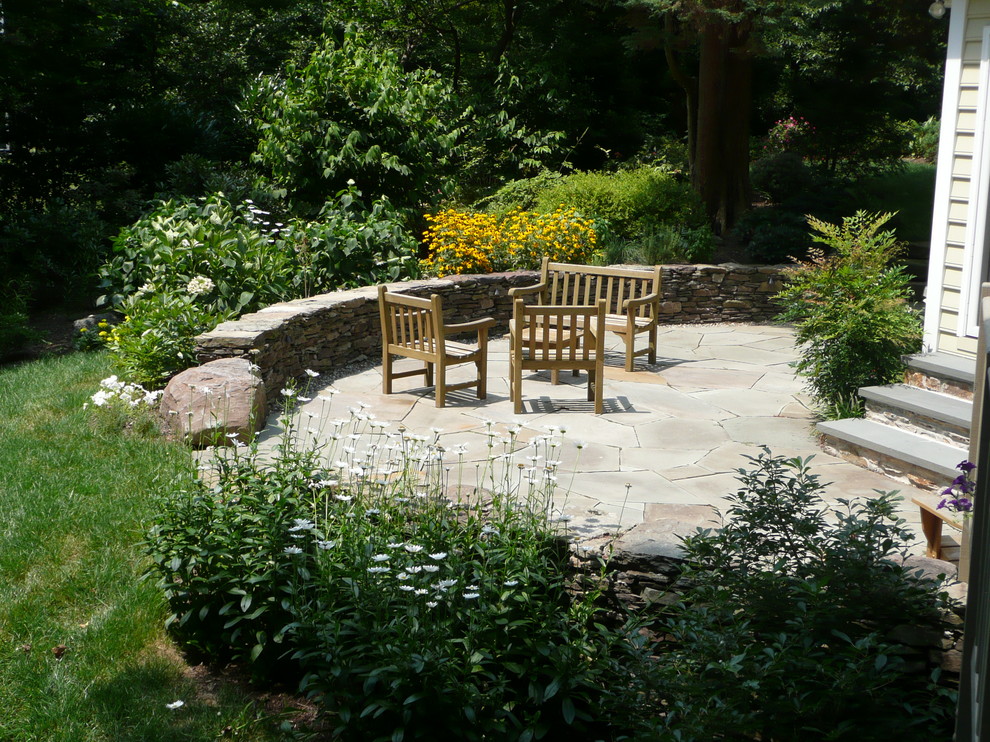 Outdoor flagstone patio with dry stack seat wall Rustic Patio