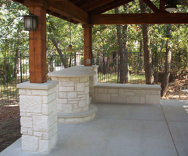 Esempio di un grande patio o portico american style dietro casa con un focolare, lastre di cemento e un tetto a sbalzo
