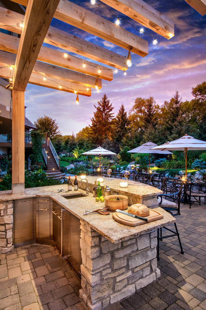 Photo of a large classic back patio in Minneapolis with an outdoor kitchen, concrete paving and a gazebo.