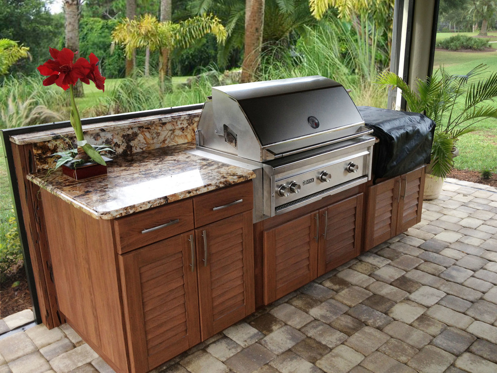 Mid-sized island style backyard concrete paver patio kitchen photo in Other with a roof extension