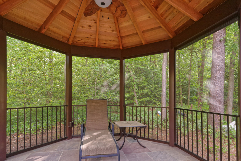 Exemple d'une terrasse arrière montagne avec une cuisine d'été, des pavés en pierre naturelle et un gazebo ou pavillon.
