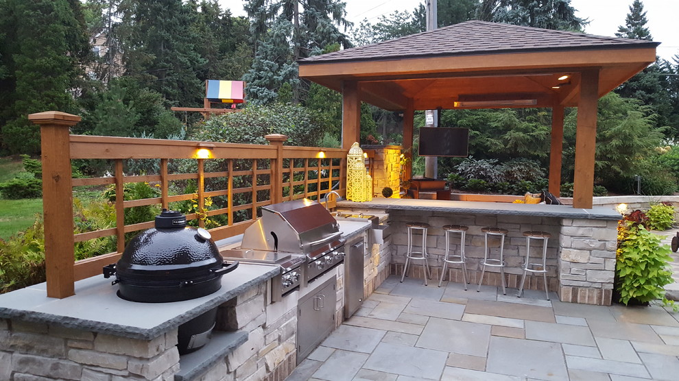 Großer Klassischer Patio hinter dem Haus mit Outdoor-Küche, Natursteinplatten und Gazebo in Milwaukee