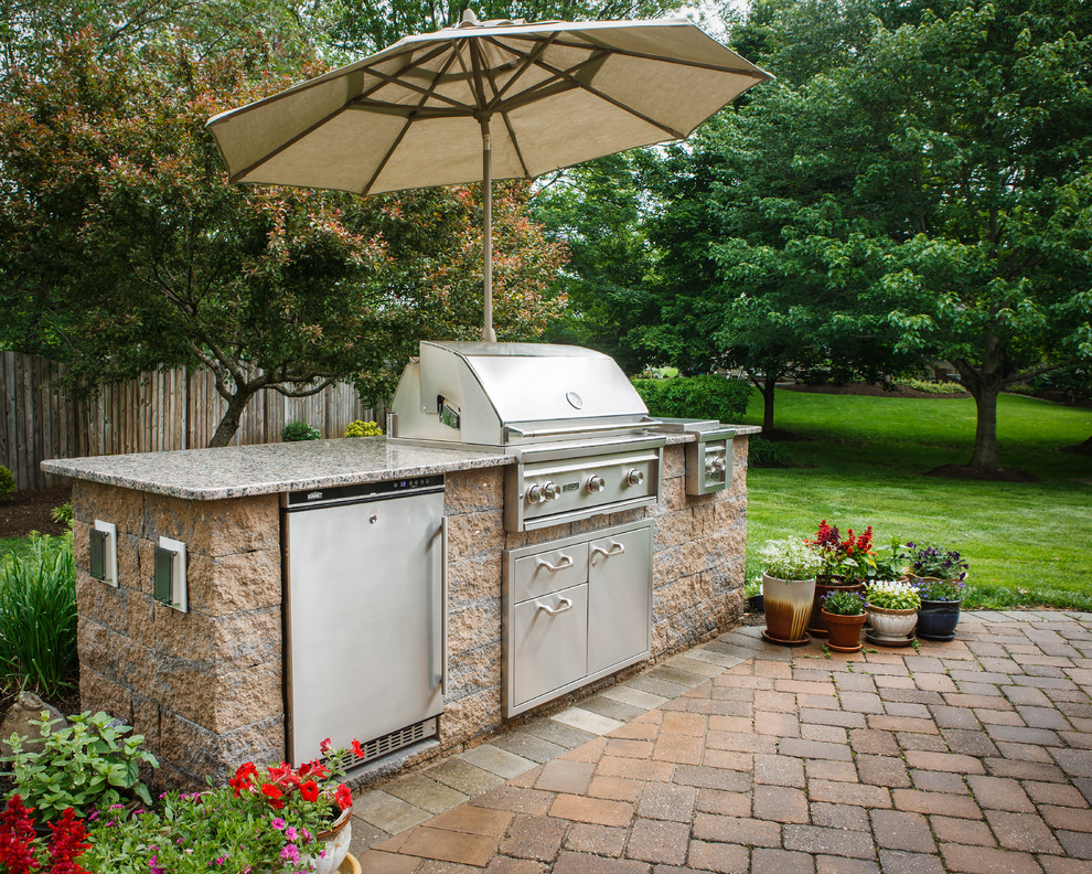 Ejemplo de patio clásico de tamaño medio sin cubierta en patio trasero con cocina exterior y adoquines de ladrillo