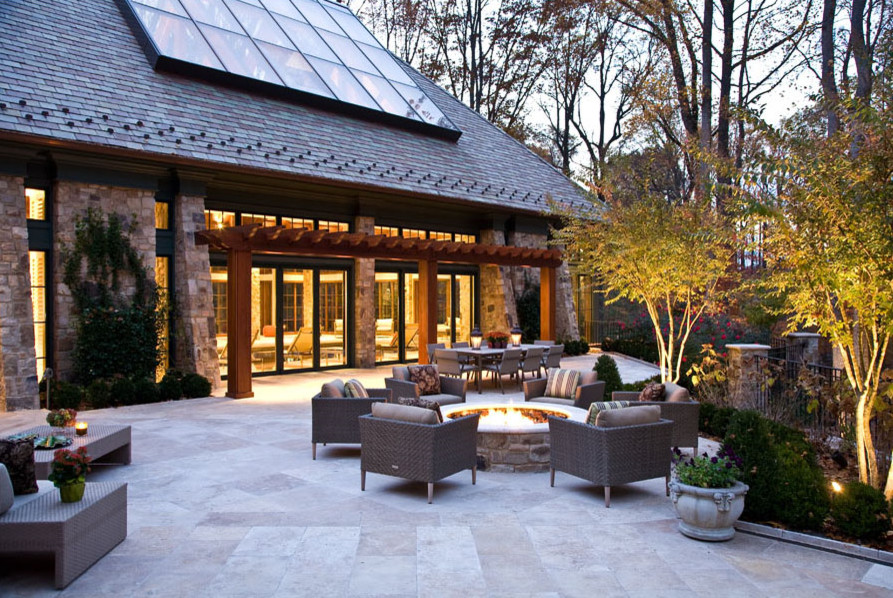 Immagine di un ampio patio o portico tradizionale dietro casa con un focolare, una pergola e piastrelle