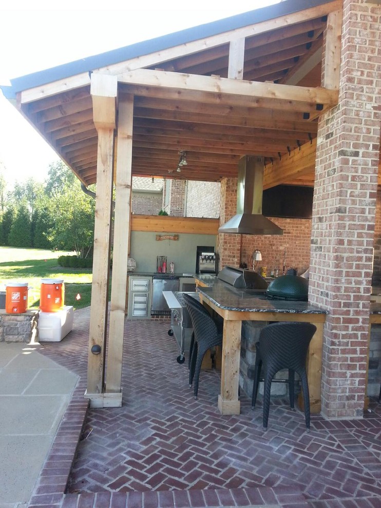 Große Klassische Pergola hinter dem Haus mit Outdoor-Küche und Pflastersteinen in Sonstige