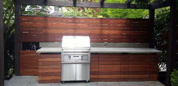 Réalisation d'une petite terrasse arrière design avec une cuisine d'été, des pavés en béton et une pergola.