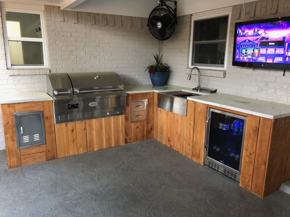Cette photo montre une petite terrasse arrière tendance avec une cuisine d'été, une dalle de béton et une extension de toiture.