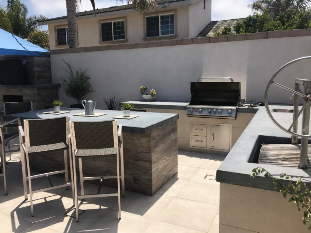 Cette image montre une terrasse arrière minimaliste de taille moyenne avec une cuisine d'été, des pavés en béton et aucune couverture.