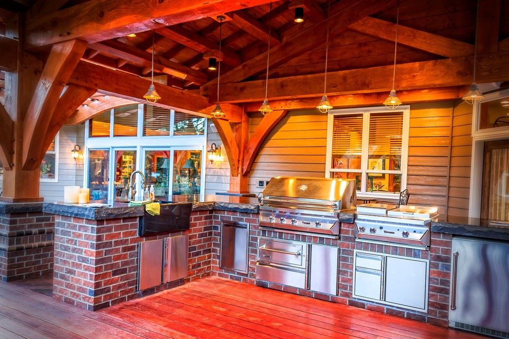 Cette image montre une terrasse arrière craftsman avec une cuisine d'été et un auvent.