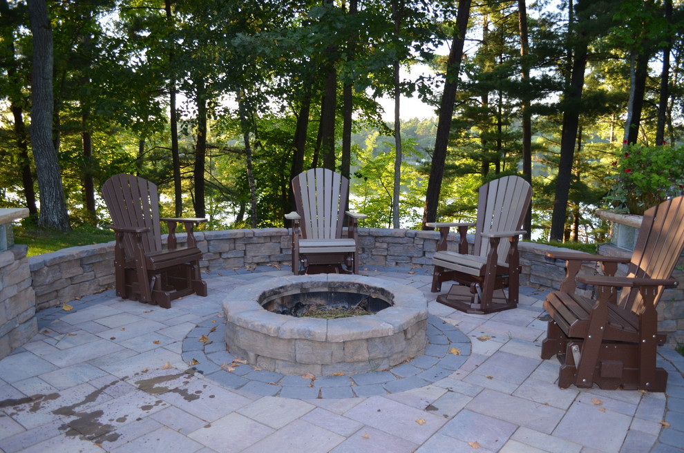 Elegant backyard stone patio photo in Minneapolis with a fire pit