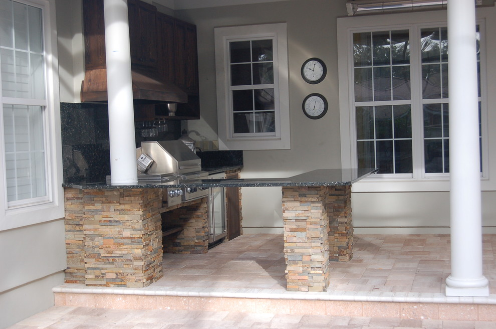 Inspiration for a mid-sized timeless backyard concrete paver patio kitchen remodel in Jacksonville with a roof extension